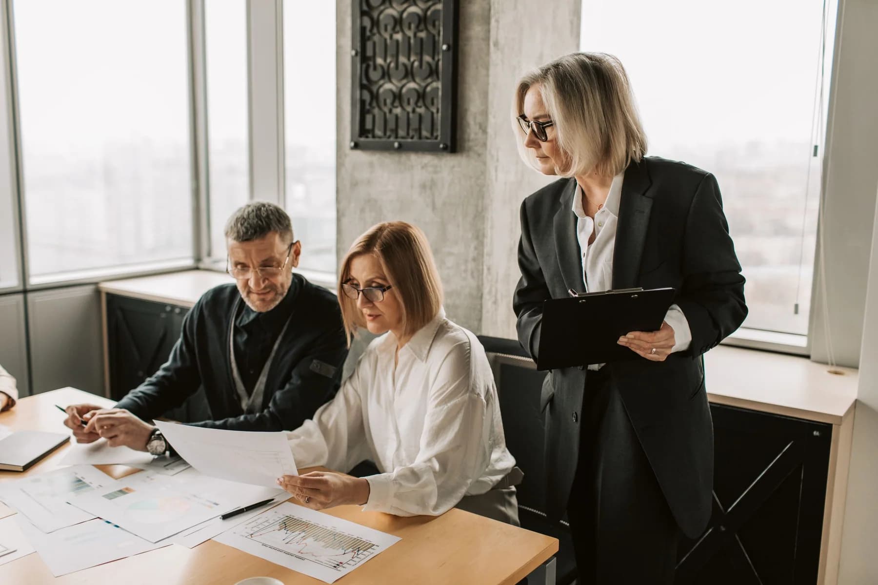 Colleagues reviewing reports and notes together at a table